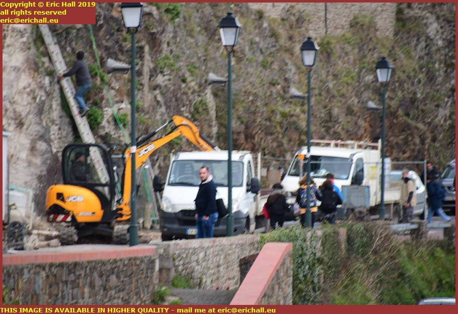 mini digger clearing building site medieval city walls Boulevard des 2E et 202E de Ligne granville manche normandy france
